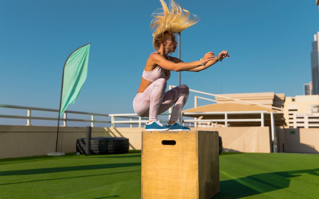 Fit young woman doing box jumping.
